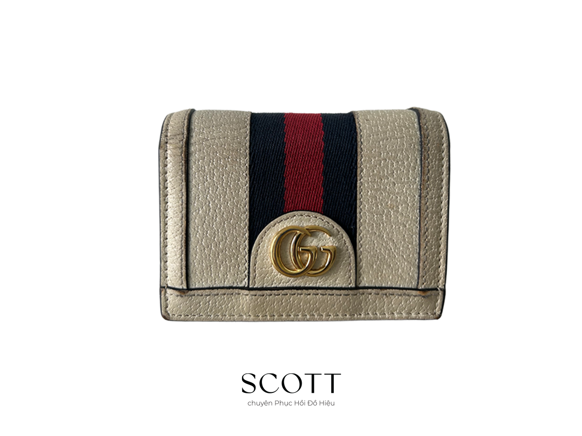Ví Gucci da thật trước khi phục hồi - SCOTT Ví Gucci da thật trước khi phục hồi – da xỉn màu, trầy xước và khô cứng.